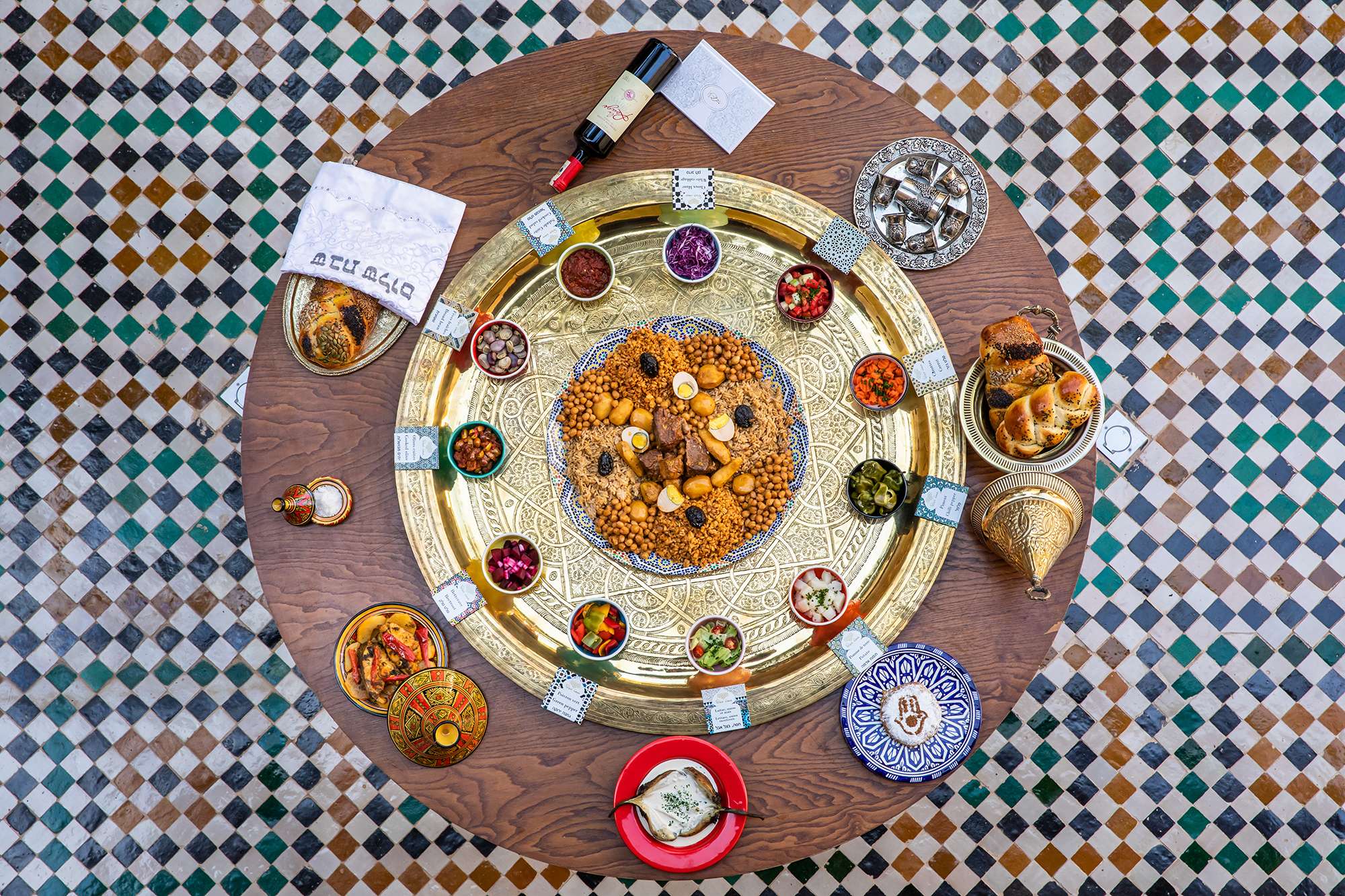Marrakech s’enrichit d’un nouveau musée consacré à l’art culinaire marocain
Par la tribune -04/11/2019
C’est dans la médina, dans le quartier du Riad Zitoun, à deux pas de l’incontournable Palais de la Bahia,que se situe le tout nouveau projet culturel de Marrakech : Le Musée d’art culinaire marocain.
Edifiée dans un magnifique riad du XVIIe laissé à l’abandon pendant des décennies, des investisseurs privés se lancent dans un vaste projet de rénovation qui durera plus de deux ans pour redonner vie à cette belle demeure. Le musée s’articule autour de deux patios : le plus grand abrite une fontaine en marbre entourée d’oliviers et d’un palmier centenaire, l’autre patio offre un tapis de zelliges fassi composé de pas moins de 100.000 petits carreaux de terre cuite émaillée sur lequel s’élève une petite fontaine. Une équipe de Maâlems marocains a su restaurer les lieux, utilisant les matériaux et le savoir-faire traditionnels pour redonner à l’ensemble du riad sa noblesse : tadelakt aux murs, ornements travaillés des gebs (plâtres ciselés), plafonds de cèdre aux tons chauds, sols en bejmats, coupoles en bois de cèdre zouakées. La réalisation et la mise en oeuvre du concept ont été confiées à M. Taoufik Ghaffouli, un professionnel doté de plus de 25 ans d’expérience dans le secteur de l’hôtellerie et du tourisme. Les visiteurs découvriront la richesse de la cuisine marocaine en circulant dans plusieurs salles dédiées à ses plats et ingrédients emblématiques : épices et herbes, salades, soupes, briouates et pastillas, tagines et couscous, cuisine juive méditerranéenne, pains, pâtisseries et thé. Les arts de la table seront également représentés. Au fil de leur déambulation, ils pourront assister à des démonstrations permettant de mieux comprendre les tours de main d’une cuisine qui se transmet oralement de mère en fille : la fabrication de l’huile d’argan, la cuisson du pain tafarnout, l’art délicat de rouler la semoule pour le couscous, la distillation de fleurs d’oranger ou de rose, le service du thé… Ceux qui voudront passer à la pratique pourront rejoindre des ateliers de cuisine marocaine dispensés par des Dadas expertes et déguster les plats qu’ils auront préparés sur la terrasse. Sur le toit, avec une vue panoramique sur la Médina, dans une ambiance «Jemaa el Fna», on pourra déguster toutes les spécialités marocaines. La visite se clôture par un passage à la boutique souvenirs.
Rue El Bahia, Riad Zitoun Jdid (en face de La Poste), Médina | ouvert de 10h à 19h 7j/7 | Tarif public : 60 dh – Marocains : 40 dh | Cours de cuisine : 500 dh par personne